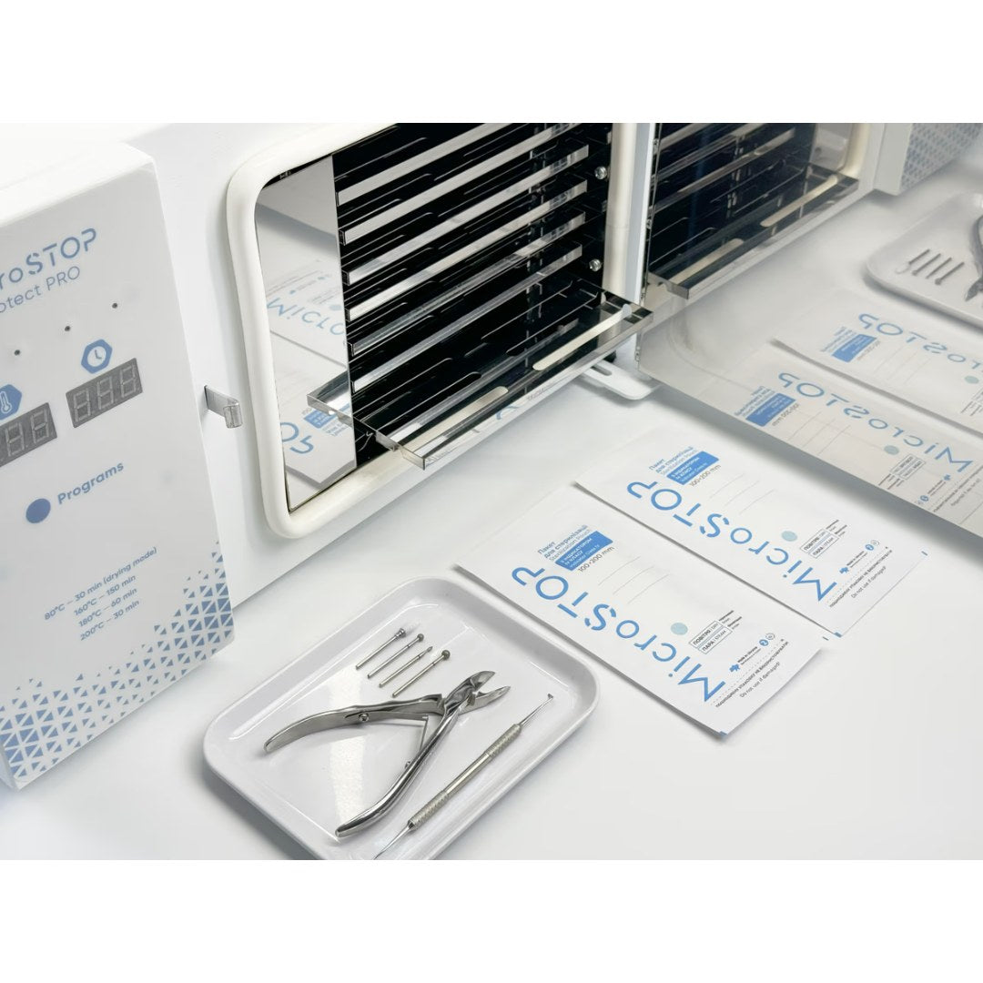 Åpen MicroSTOP PROTECT PRO med hyller, foran ligger instrumenter og steriliseringsposer
