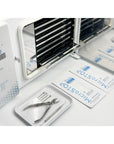 Åpen MicroSTOP PROTECT PRO med hyller, foran ligger instrumenter og steriliseringsposer